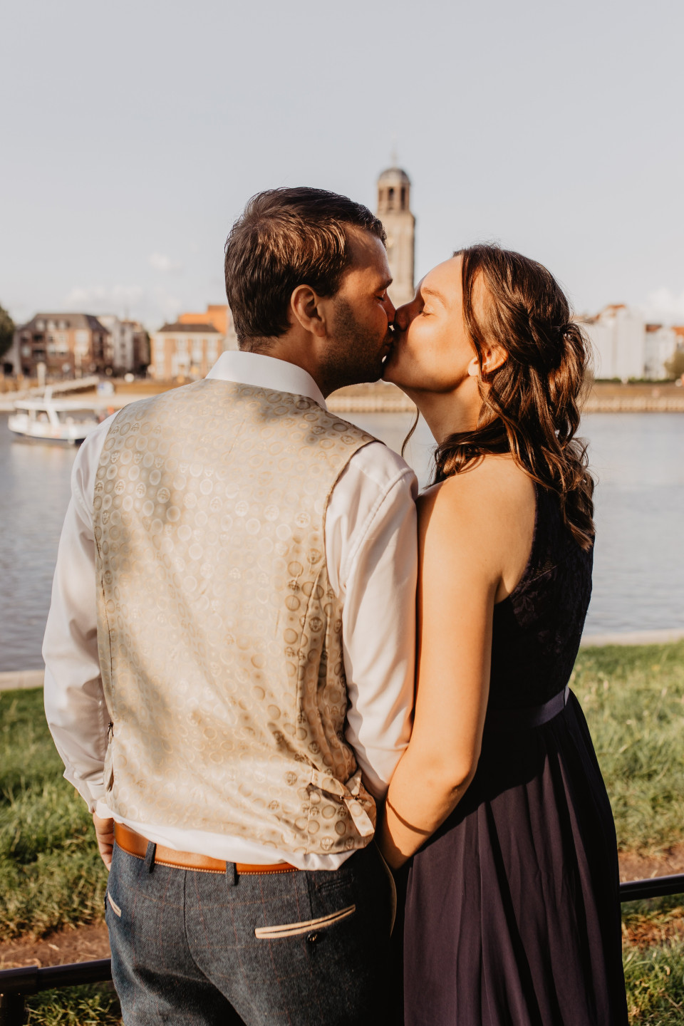 een man en een vrouw die elkaar kussen voor een waterlichaam