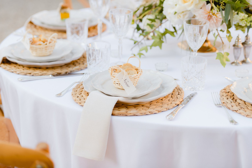 een tafelsetting met witte borden en tafelgerei