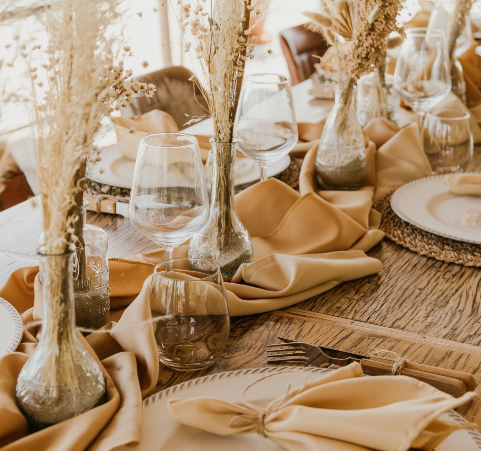 een tafelsetting met gouden servetten en tafelschikkingen