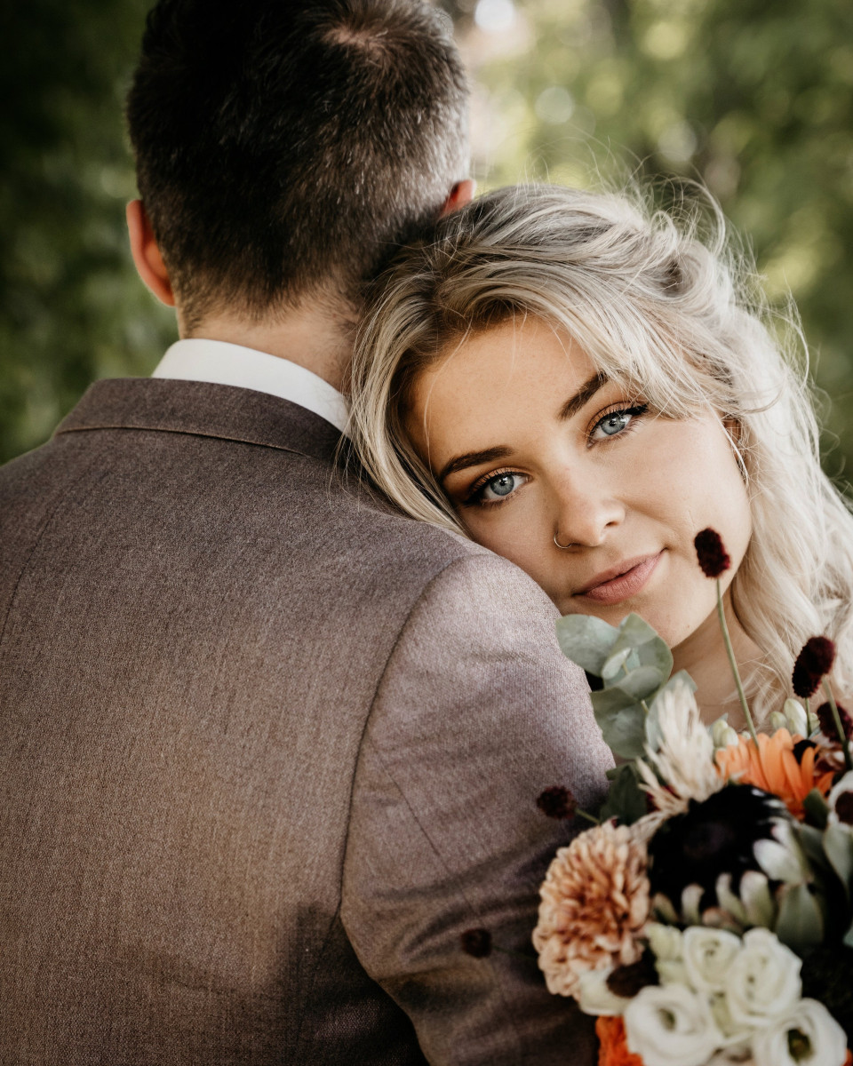 een mooie bruid en bruidegom omhelzen elkaar in het bos