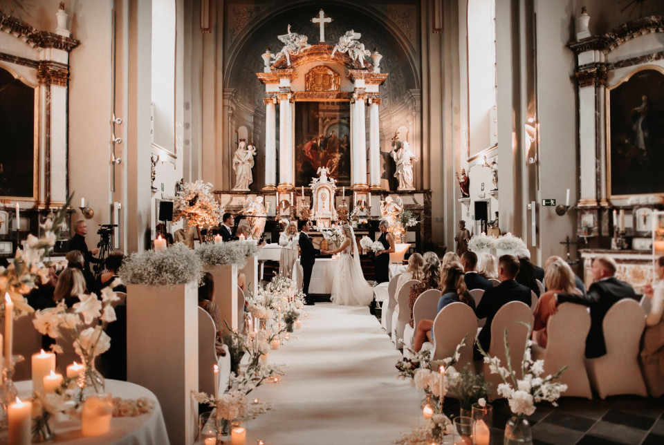 bruiloftsceremonie in een kerk met kaarsen en bloemen