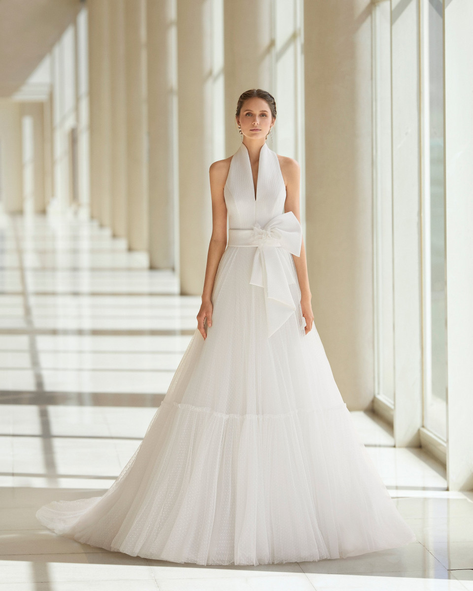 de trouwjurk is een witte jurk met een strik