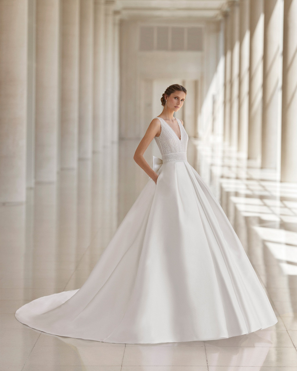 de bruid draagt een witte trouwjurk met een diepe v-hals