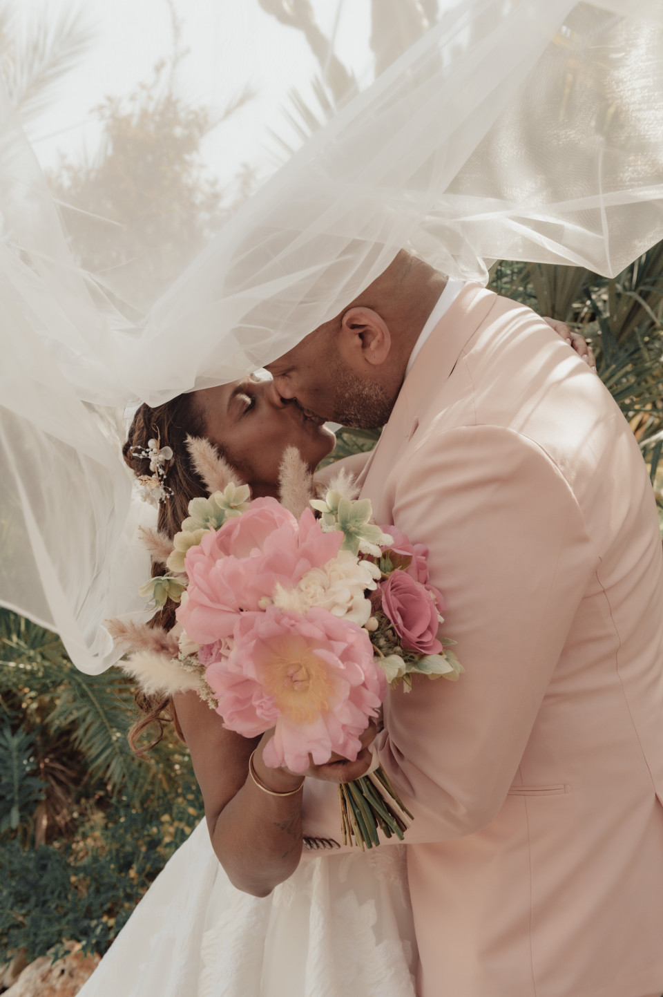 het bruidspaar dat onder de sluier kust