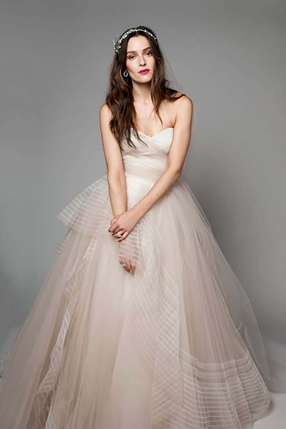 een vrouw in een trouwjurk poseert voor de camera