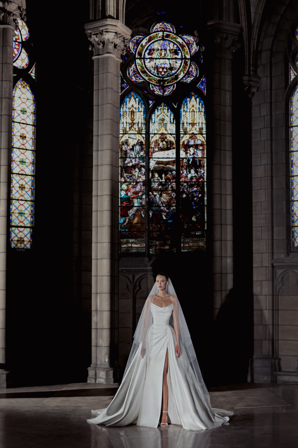 een bruid in een kathedraal met glas-in-loodramen