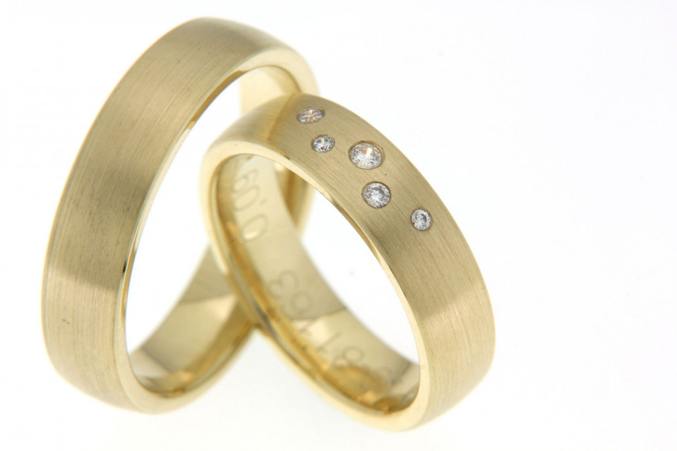 twee trouwringen met diamanten in geelgoud