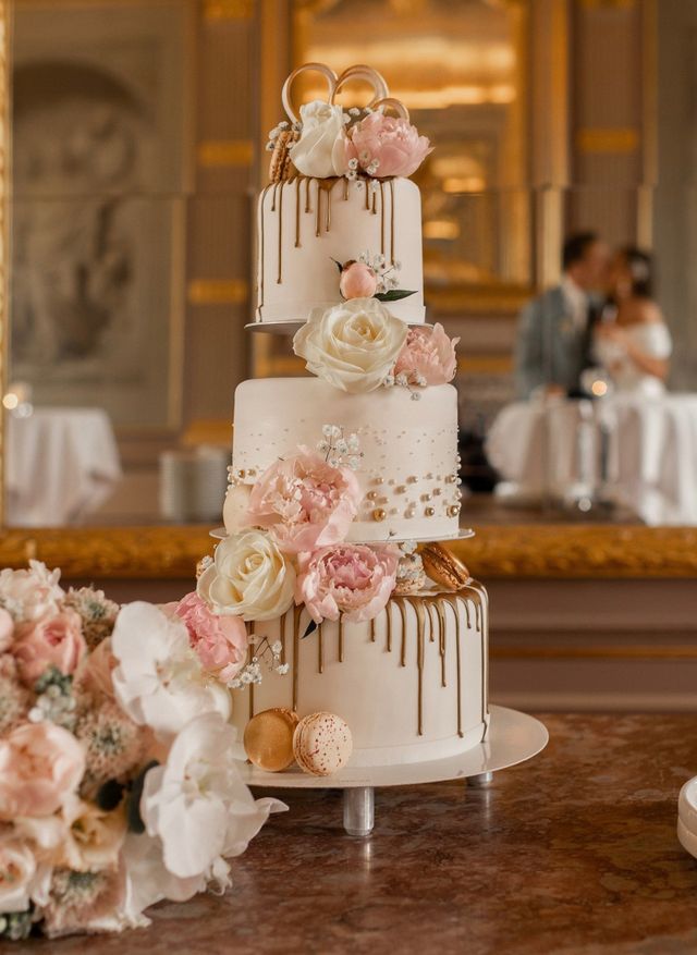 Dreistöckige Hochzeitstorte mit goldenen Perlen und Blumendeko