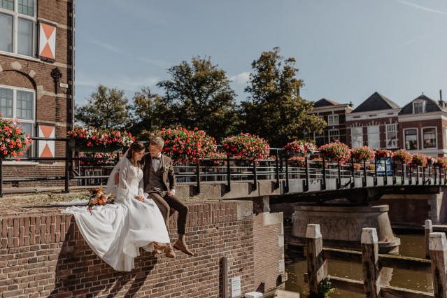 Brautpaar auf Steinbrücke sitzend
