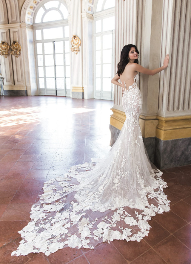Braut in einem Fit and Flare Brautkleid aus Spitze mit langer Schleppe und tiefem Rückenausschnitt