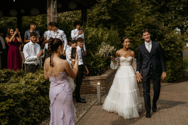 gast fotografeert bruidspaar