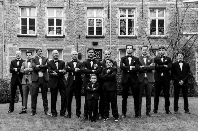 Groom and groomsmen in black tuxedos with bow ties