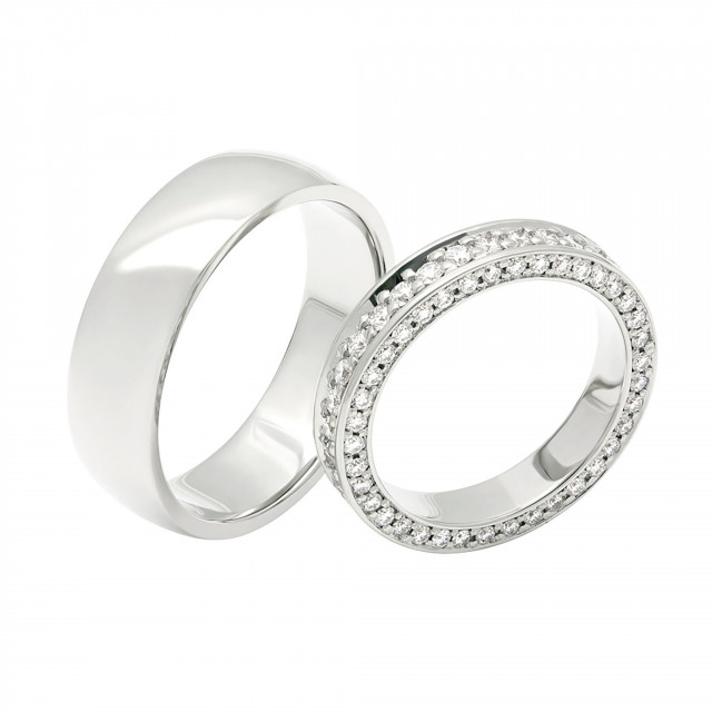 twee trouwringen met diamanten op een witte achtergrond