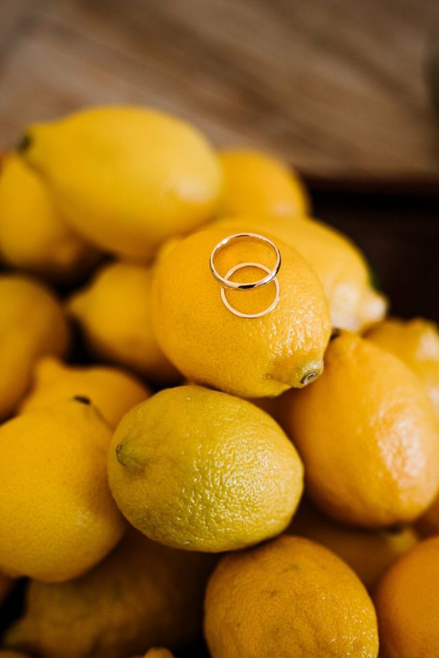 Two gold wedding rings rest together atop a bed of fresh flowers.
