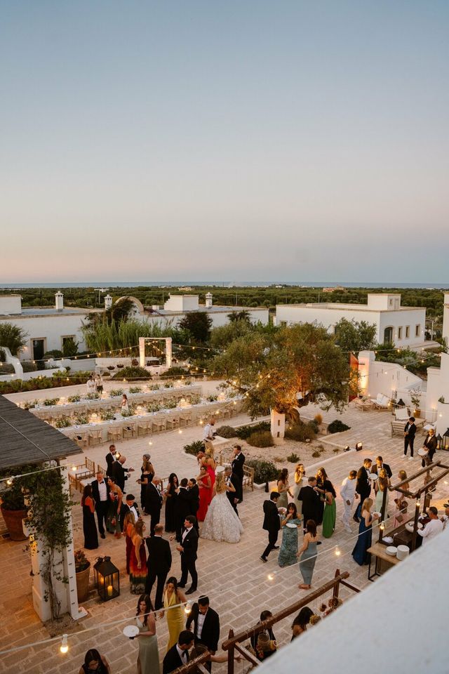 Aerial overview of a wedding venue with guests gathered on a courtyard.