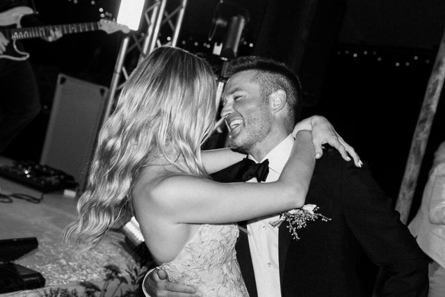 A black and white photo of the couple laughing together during the celebration.