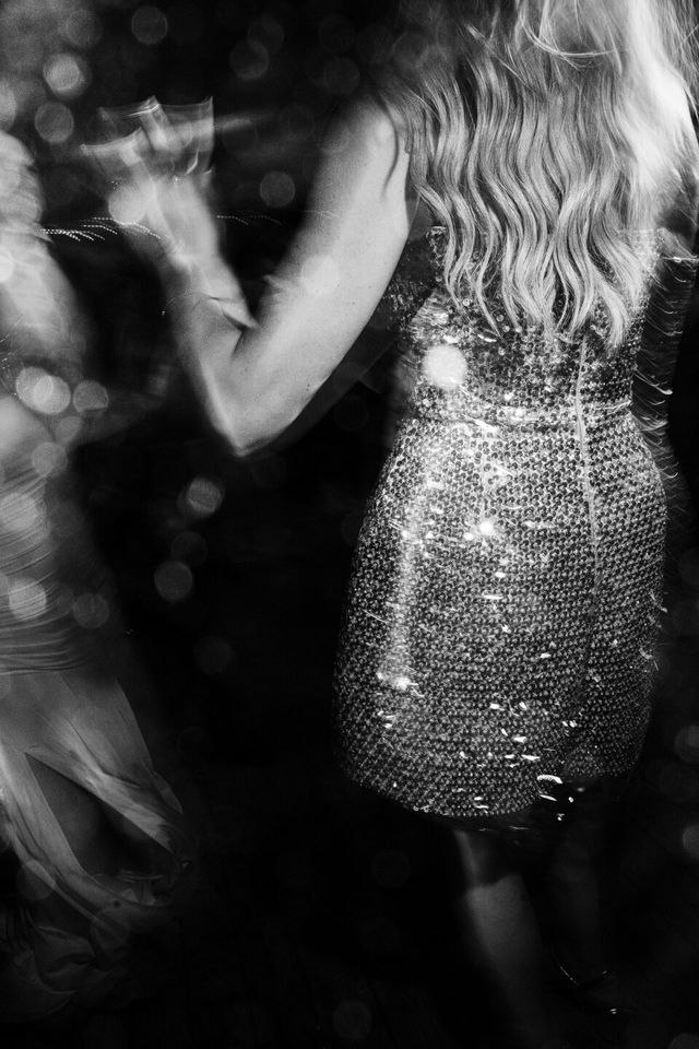 Atmospheric motion shot of a woman in a sequined dress on the dance floor.