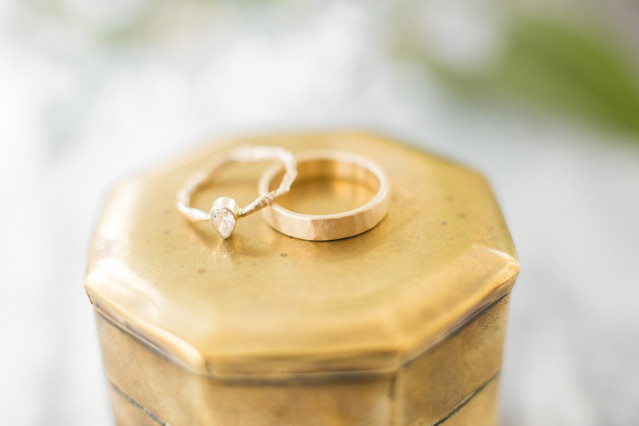 Deux alliances en or posées sur un coffret doré, symbole classique de l'engagement