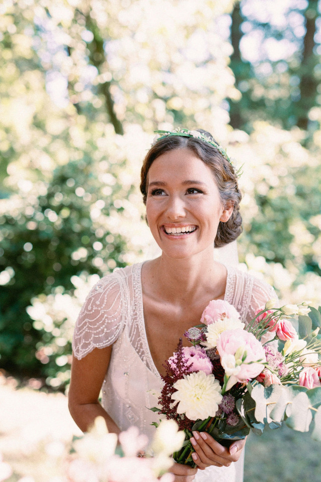 mariée souriante avec un bouquet de mariée