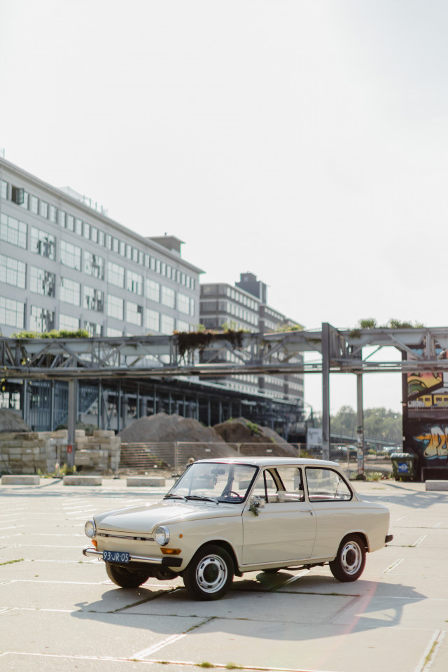 industriële trouwlocatie met vintage auto ervoor