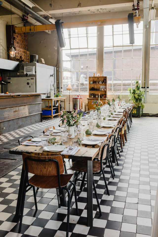 Industriele trouwlocatie met lange tafels voor diner