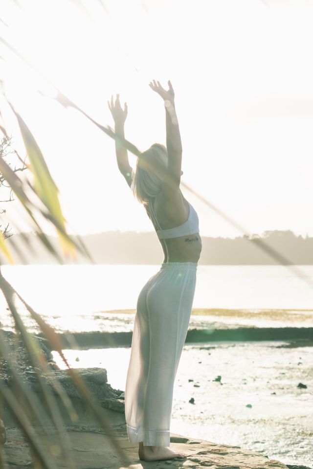 Frau macht Yoga am Strand