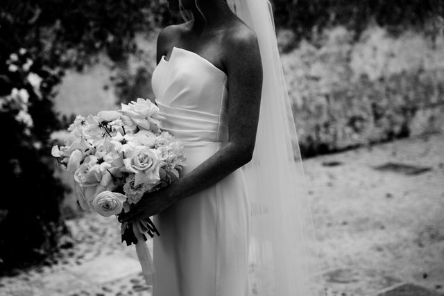 A black and white photo of the bride holding her white bridal bouquet.