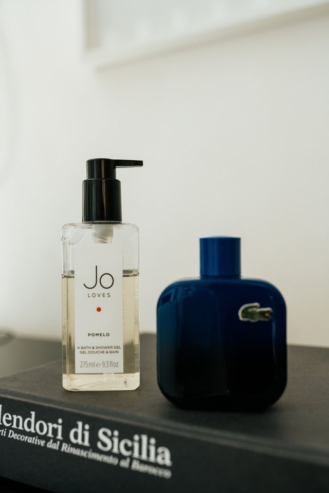 A bottle of fragrance and bath products styled on the getting-ready table.