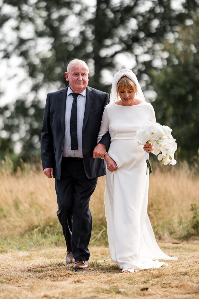 Braut mit Vater schreitet zum Altar