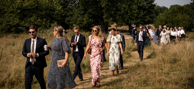 Hochzeitsgesellschaft läuft auf einem Wanderweg entlang