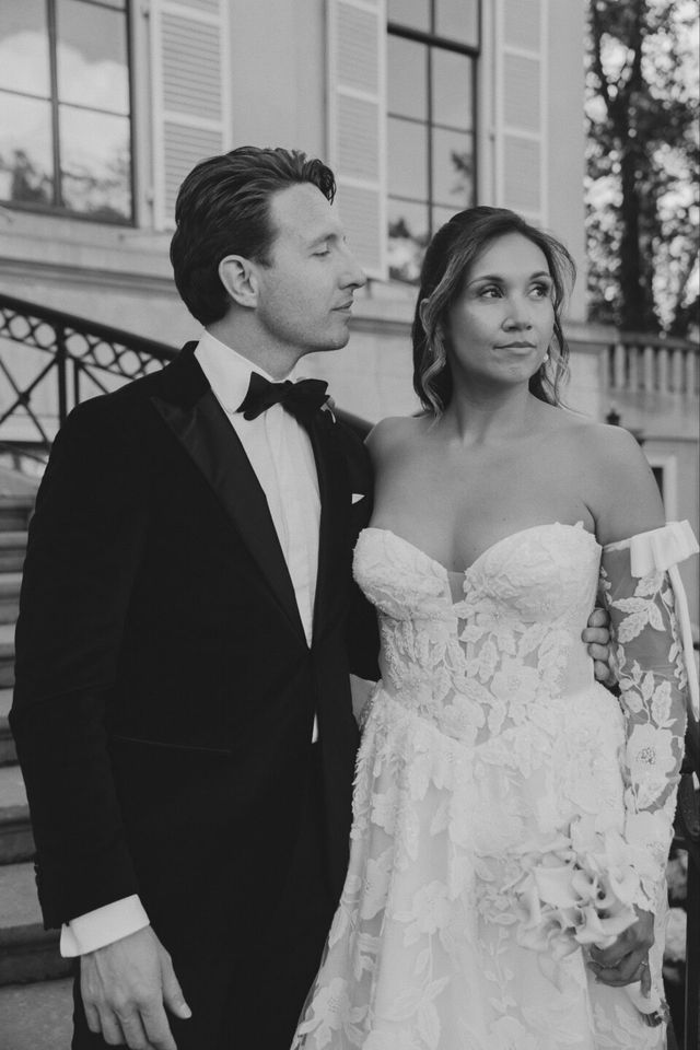 Couple in formal white tie wedding attire outside a mansion
