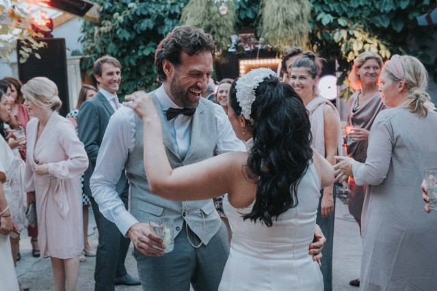 The couple dances and laughs among their guests at the outdoor reception.