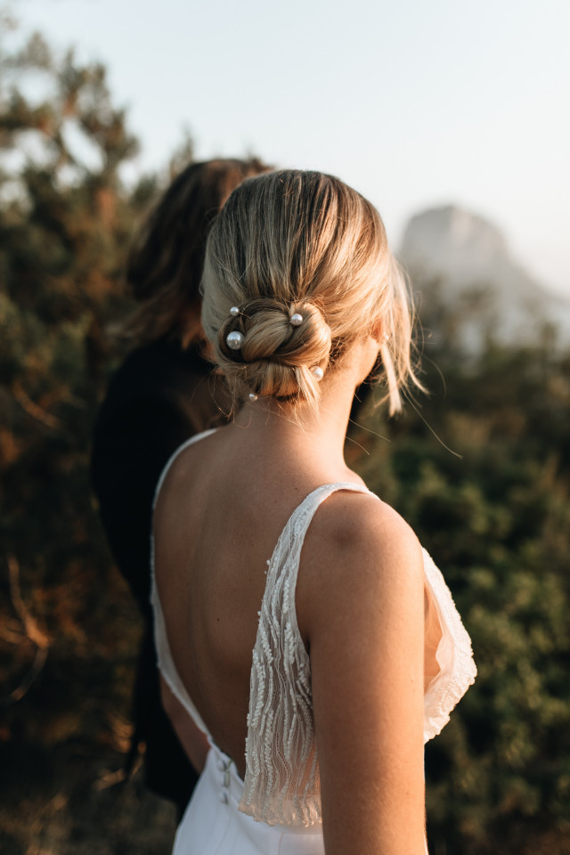 bruidskapsel in blond haar met knot en parels