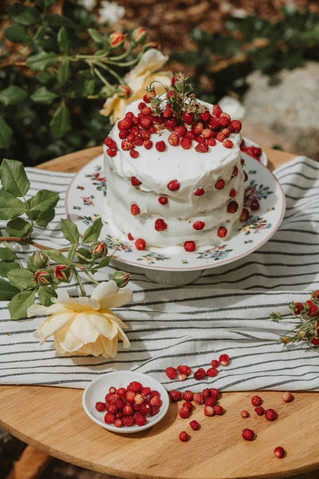 Kline weiße Torte mit kleinen Erdbeeren