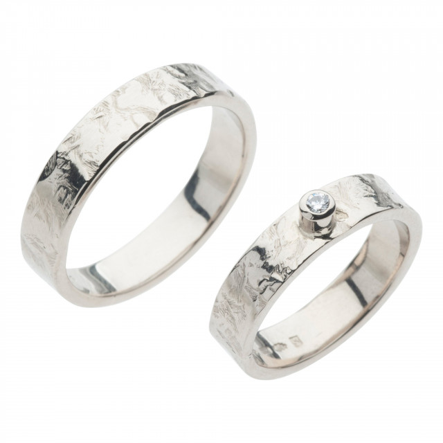 twee trouwringen met een diamant gezet in witgoud