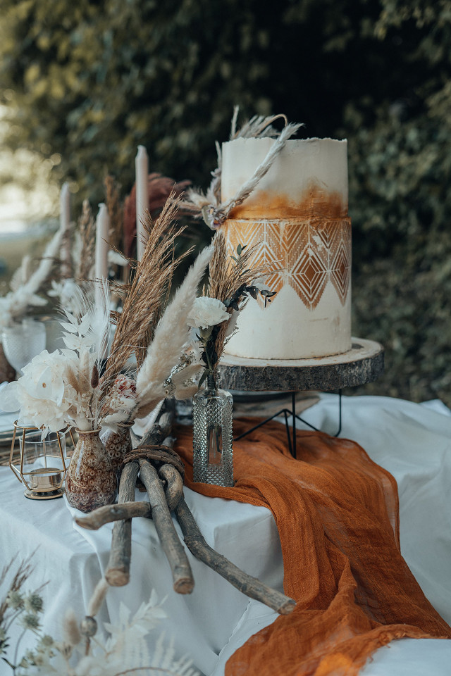 Zweistöckige Hochzeitstorte mit goldener Verzierung im Boho Stil