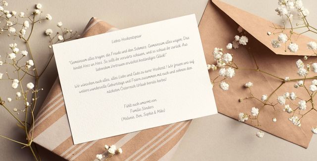 Hochzeitskarte horizontal beschrieben mit Hochzeitswünschen umgeben von Blumen und einem braunen Briefumschlag