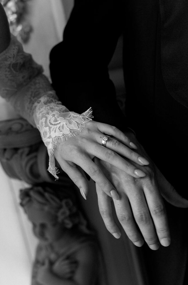 Couple's hands together, both wearing wedding rings