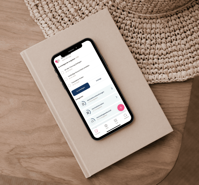 Checkliste auf Ipad auf einem braunen Buch und braunem Tisch