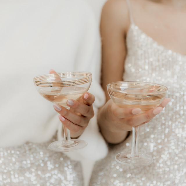 Zwei Frauen stoßen mit Cocktailgläsern an