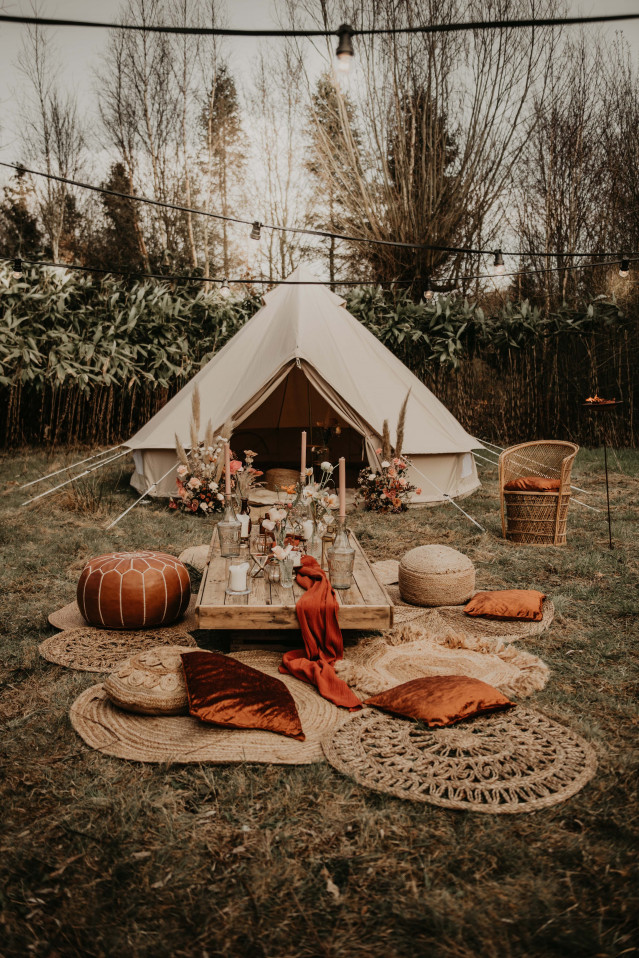 Glamping Hochzeitsdeko mit Zelt und Kissen auf einer Wiese