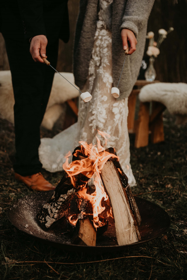 Brautpaar röstet Marshmallows über Lagerfeuer
