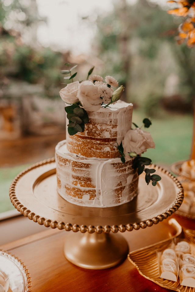 Naked Cake mit weißem Zuckerguss und Blumendekoration