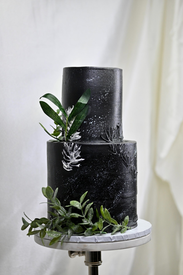 schwarze Hochzeitstorte mit grünen zweigen