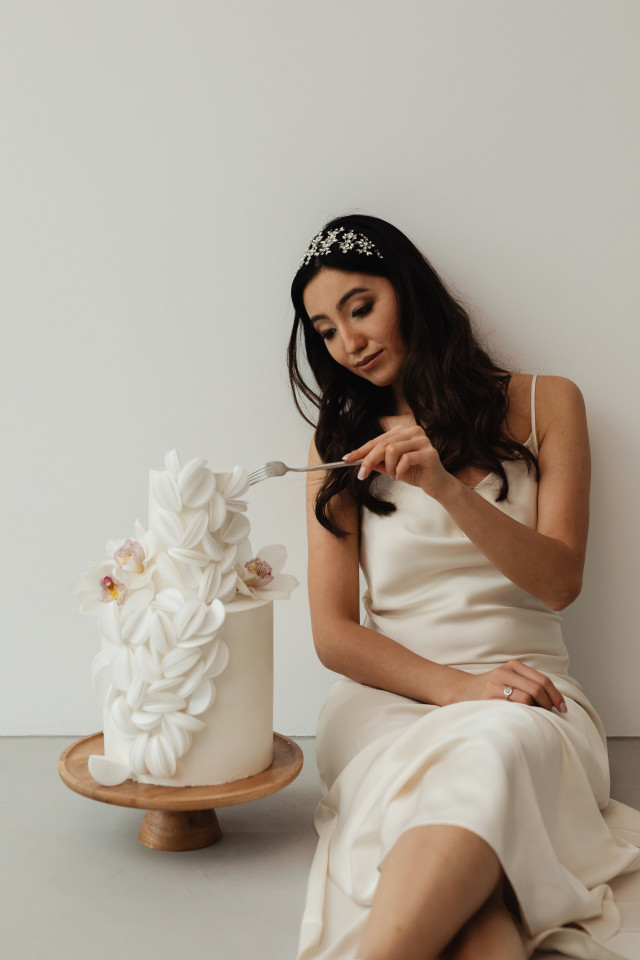Frau sitzt auf Boden und isst Hochzeitstorte