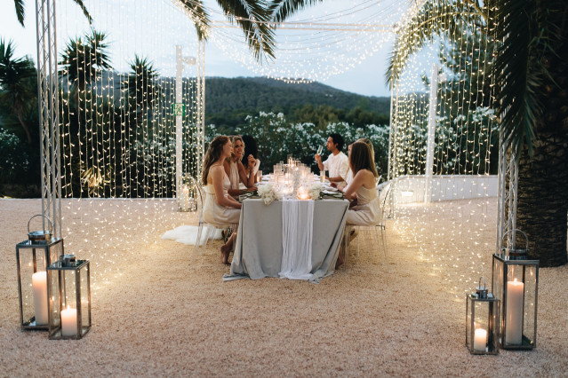 Brautpaar an Hochzeitstisch mit Lichterketten 