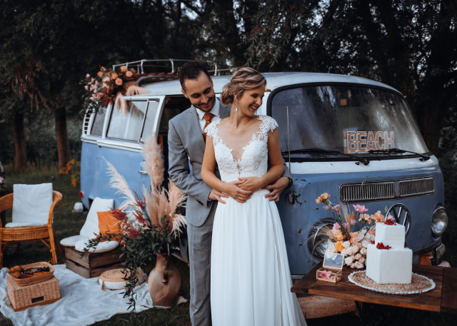 Brautpaar vor blauem VW Bus