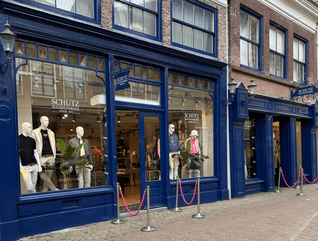 een winkelgevel met etalages met mannequins
