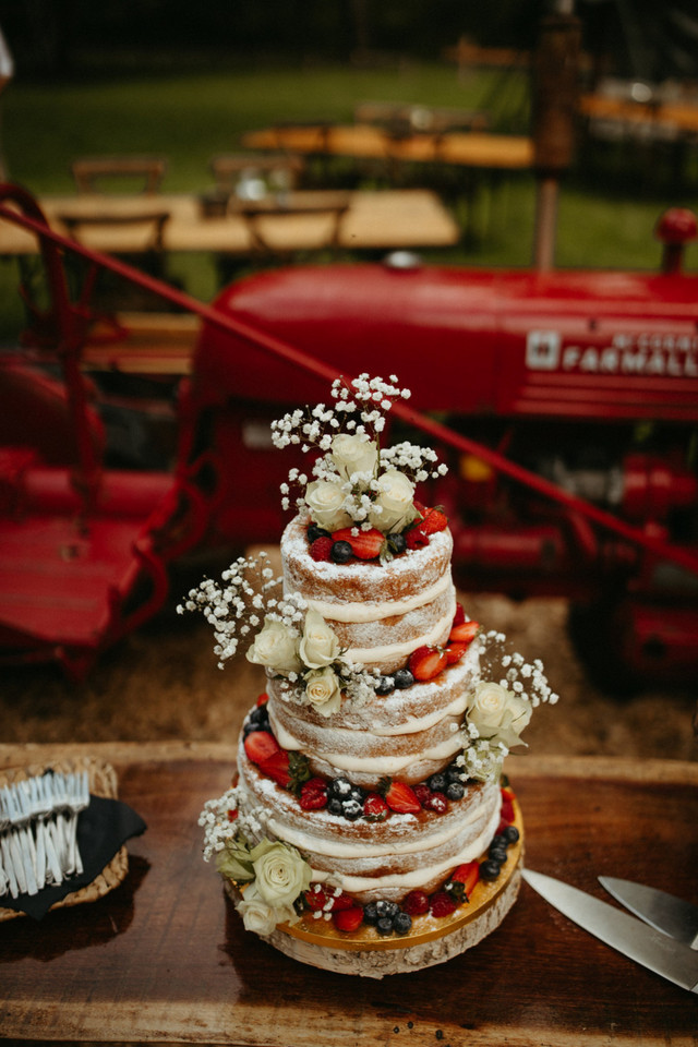 Naked Cake mit frischen Blumen auf einem Holztisch