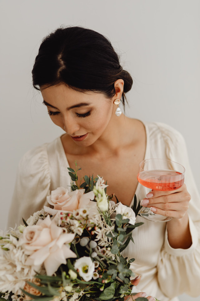 Braut mit Champagnerglas und Brautstrauß